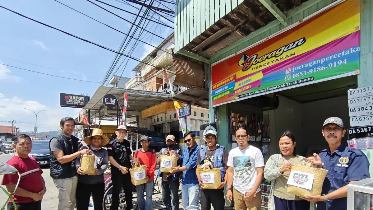 BERBAGI: Anggota PWI Tanah Bumbu menyerahkan paket sembako kepada warga dalam kegiatan PWI Tanah Bumbu Peduli. (Foto: Zulqarnain/Radar Banjarmasin)