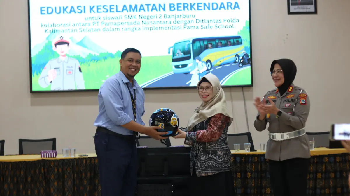 HELM: BBSO Head PT Pamapersada Nusantara Arif Cahyadi menyerahkan helm SNI secara simbolis kepada Kepala SMKN 2 Banjarbaru sebagai bagian dari edukasi keselamatan berkendara.