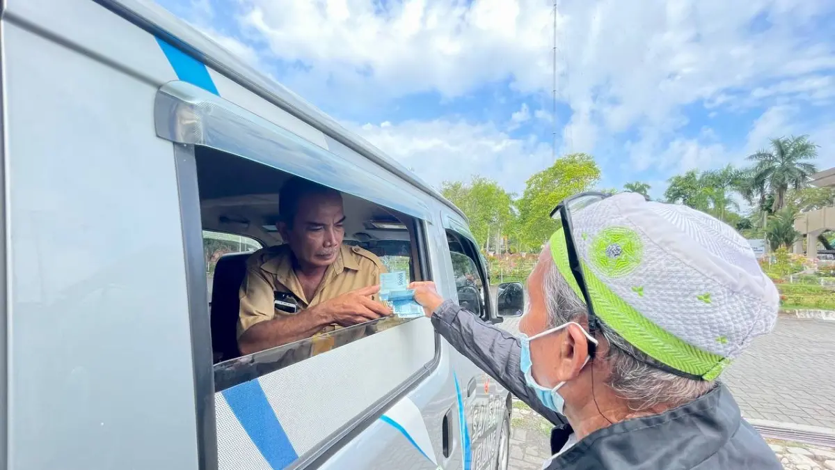 PELAYANAN: Petugas samsat (dalam mobil) melayani warga yang ingin melakukan pembaruan Pajak Kendaraan Bermotor (PKB) pada pelayanan Samsat Keliling Banjarmasin 2 di halaman Masjid Raya Sabilal Muhtadin Banjarmasin.(Foto: BAPENDA Kalsel)