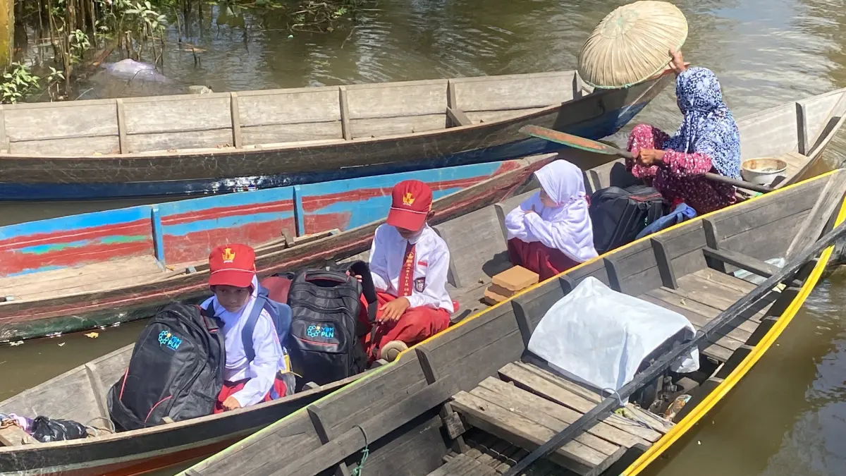 PENUH PERJUANGAN: Potret beberapa murid SDN Basirih 10 yang harus menggunakan kelotok atau perahu kecil untuk berangkat ke sekolah karena sulitnya akses jalan.