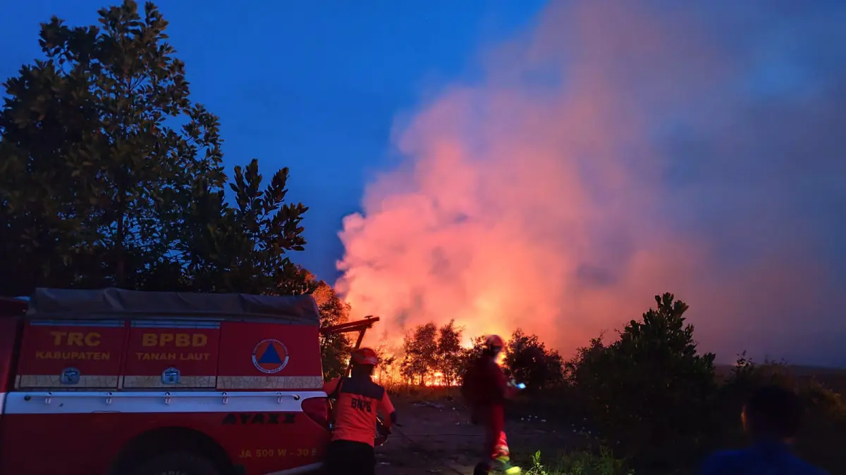 BAHU-MEMBAHU : Petugas dari BPBD dan tim gabungan melakukan pemadaman lahan yang terbakar di wilayah Desa Kayu Abang dan Gunung Raja, Kecamatan Tambang Ulang, Kamis (13/8/2026) sore. (Foto : Angga untuk Radar Banjarmasin)