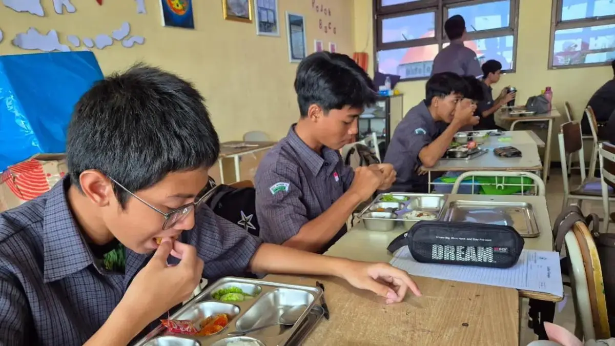 SANTAP: Siswa SMA Negeri 10 Surabaya sedang menyantap menu MBG. Orang tua nantinya bisa memantau langsung sajian menu yang diberikan. (Foto: Novia Herawati/ Jawa Pos)