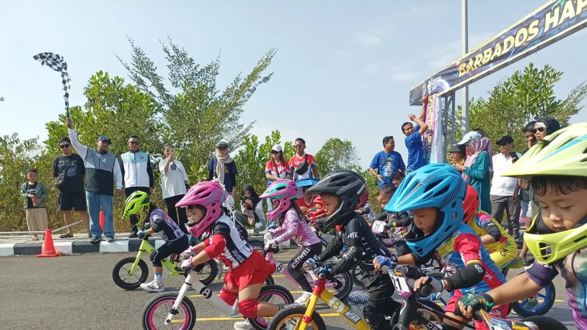 MENGIBARKAN: Kepala Dispora Kalimantan Selatan, Pebriadin Hapiz, mengibarkan bendera start pada Happy Race Pusbike 2026 di halaman GOR Babussalam, Banjarbaru, Sabtu (15/8/2026). (M Idris Jian Sidik)