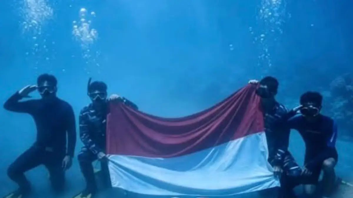 AKSI: Prajurit Jalasena Lanal Kotabaru membentangkan bendera Merah Putih di dasar laut perairan Pulau Samber Gelap, Kotabaru, Senin (17/8). (Foto: Pen Lanal Kotabaru)