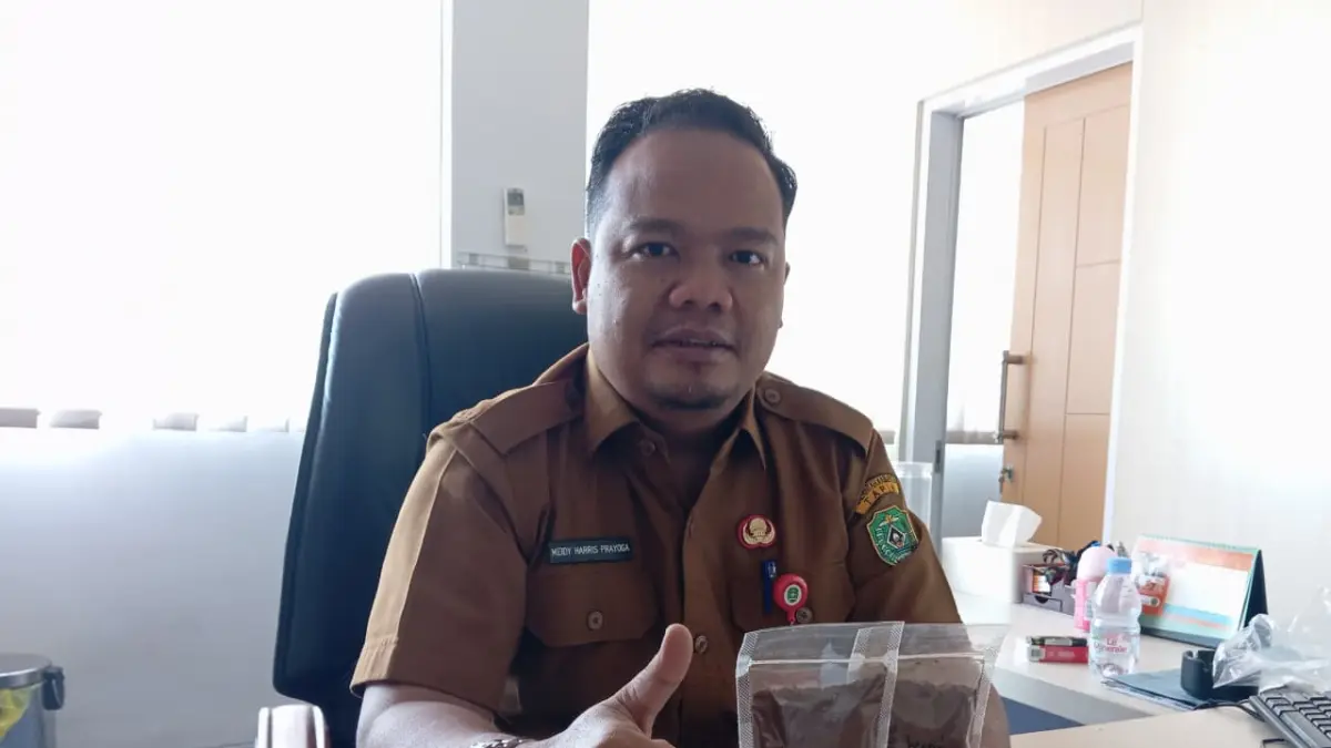 DIKEMBANGKAN: Kepala Bappelitbang Tapin Meidy Harris Prayoga memperlihatkan hasil kopi lahan rawa Desa Hiyung yang sudah di-roasting.