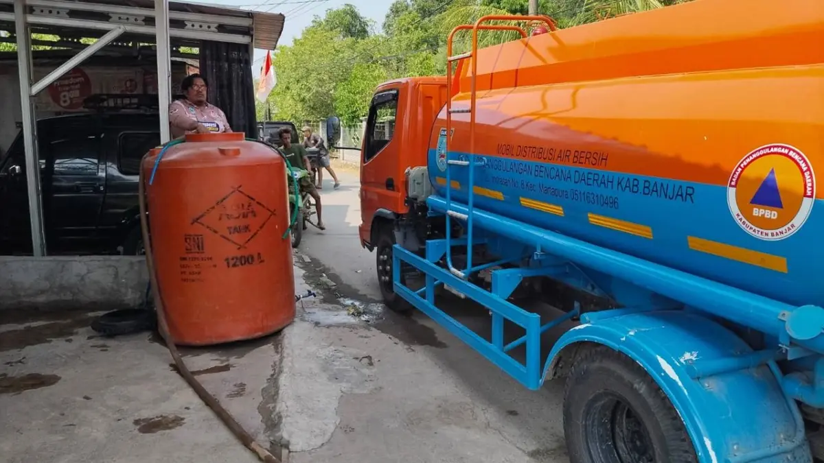 DISTRIBUSI AIR: Petugas BPBD Kabupaten Banjar menyalurkan air bersih untuk memenuhi kebutuhan warga di tengah meluasnya dampak kekeringan. (BPBD BANJAR)