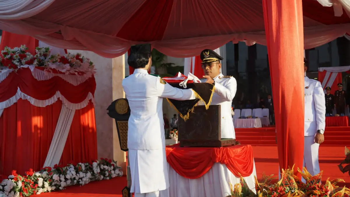 SERIUS: Wakil Bupati Kotabaru, Syairi Mukhlis menerima Bendera Merah Putih dari anggota Paskibraka dalam prosesi penurunan bendera HUT ke-81 Kemerdekaan RI di Halaman Kantor Bupati Kotabaru, Sebelimbingan, Senin (17/8/2026) sore.(Foto: Diskominfo Kotabaru)