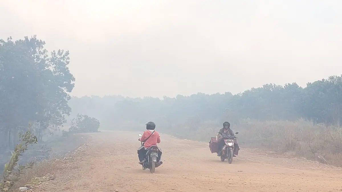 Aktivitas warga di tengah kabut asap akibat karhutla di Kabupaten Banjar. Disdik Banjar membuka opsi PJJ bagi satuan pendidikan yang terdampak kabut asap pekat. FOTO: DOK/RADAR BANJARMASIN