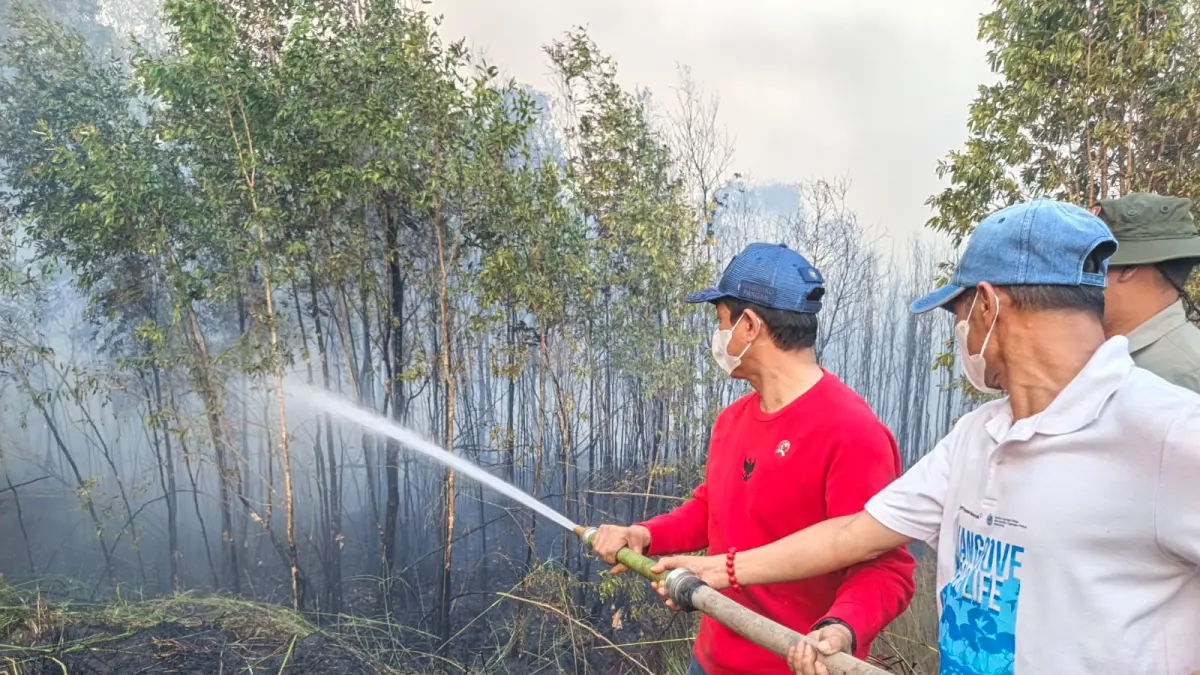 MEMADAMKAN: Wakil Menteri Koordinator (Wamenko) Bidang Pangan, Hanif Faisol Nurofiq, turun langsung meninjau sekaligus membantu penanganan titik api di kawasan Pengayuan, Kelurahan Landasan Ulin Selatan, Kecamatan Liang Anggang, Banjarbaru, Selasa (18/8). 