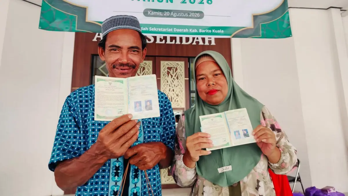 BAHAGIA: Maslam dan Paridah menunjukkan buku nikah setelah mengikuti sidang isbat nikah terpadu di Barito Kuala. (Foto: Maulana/Radar Banjarmasin)