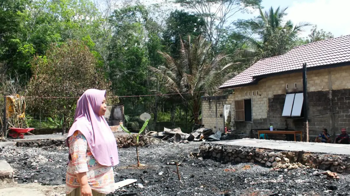 PASCAKEBAKARAN: Kepala Desa Selaselilau Mawar melihat rumahnya yang terbakar. Kerugiannya ditaksir mencapai Rp1,5 Miliar. (Foto: BPBD Tanah Bumbu)