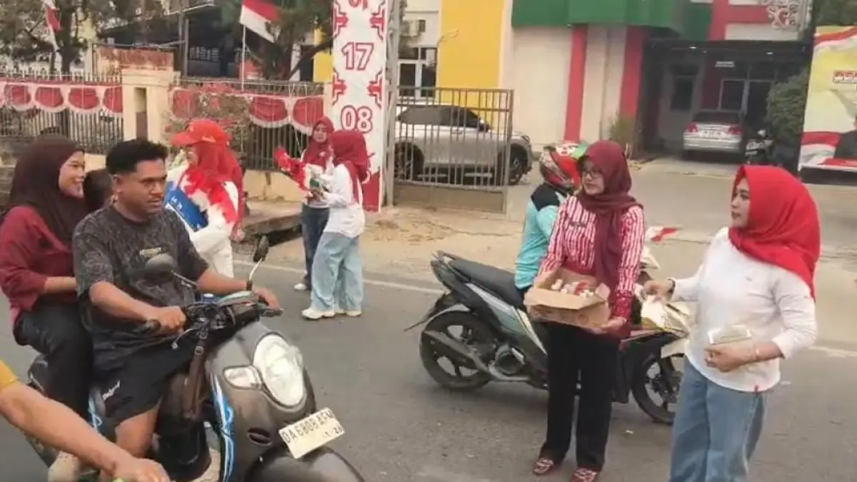 BERBAGI: Anggota Gatriwara Kabupaten Tapin saat membagikan masker dan minuman sehat ke pengguna jalan.