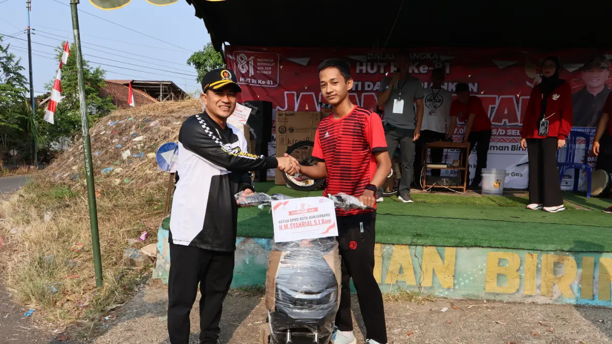 DOORPRIZE: Peserta beruntung menerima hadiah sepeda listrik yang diserahkan langsung Ketua DPRD Kota Banjarbaru H Muhammad Syahrial dalam kegiatan jalan santai.