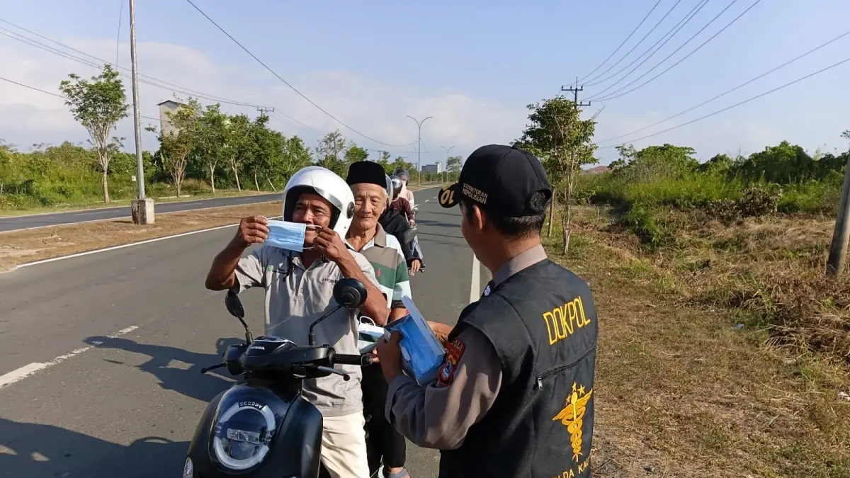 MASKER: Petugas Polres Tanah Bumbu membagikan masker kepada pengendara sebagai upaya mencegah ISPA akibat paparan asap karhutla. (Foto: Humas Polres Tanah Bumbu)