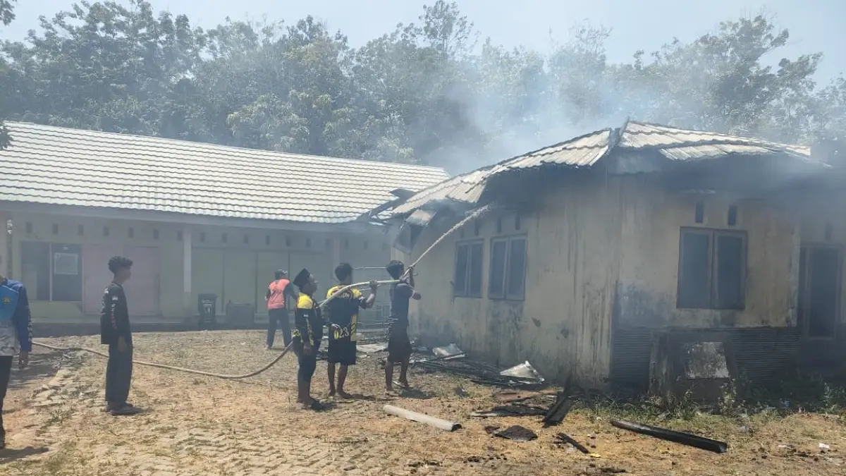 PADAMKAN: Petugas di lapangan saat mencoba memadamkan api yang membakar bangunan di Desa Parandakan. (Foto: Pusdalops BPBD Tapin)&nbsp;