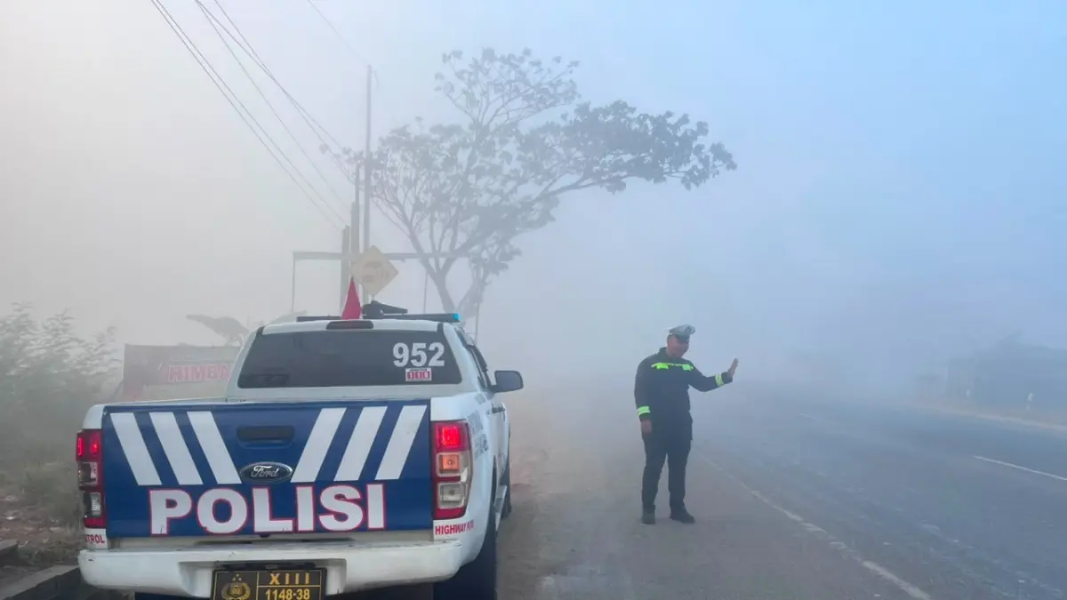 Personil dari Sat Lantas Polres Tala melakukan patroli di Jalan A Yani Bati-Bati yang mulai diselimuti kabut asap, Rabu (26/8/2026). (Humas Polres Tala)

