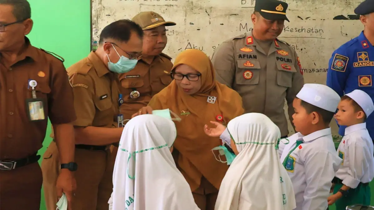 MENINGKAT: Kepala Dinkes Tala dr Hj Isna Farida membagikan masker kepada pelajar yang terdampak kabut asap di Desa Pandahan, Kecamatan Bati-Bati pada Senin (24/8/2026) lalu.