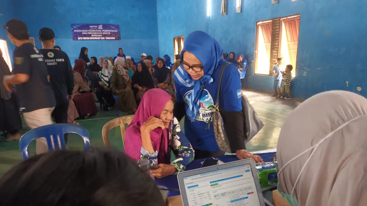 MENEGUR WARGA: Ketua Fraksi Demokrat DPRD Tabalong, Hj Mulyana menyapa warga yang memeriksakan kesehatan gratis.