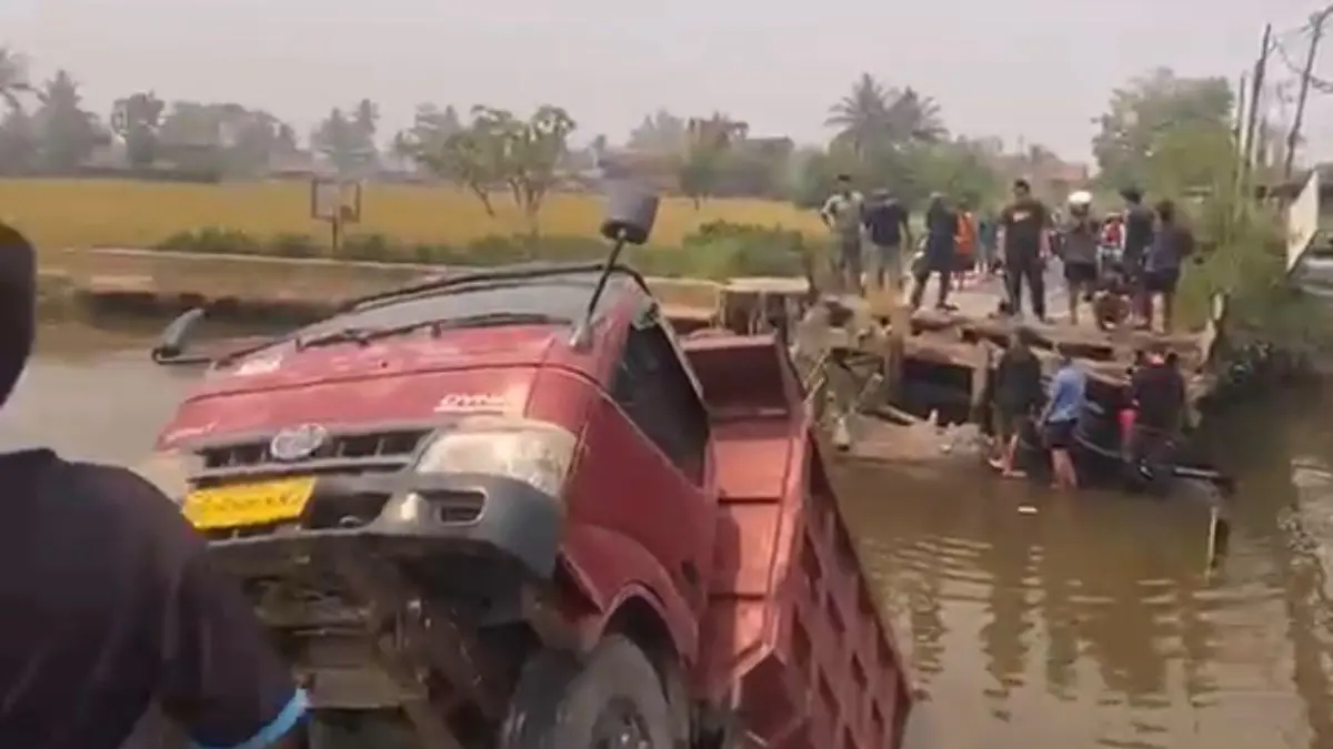 Jembatan di Jalan Tembus Mantuil, Kelurahan Basirih, Banjarmasin Selatan, ambruk pada Minggu (30/8/2026). Sebuah dump truck dan sepeda motor terjebak di bawah jembatan. (Foto: Tangkapan Layar Warga)