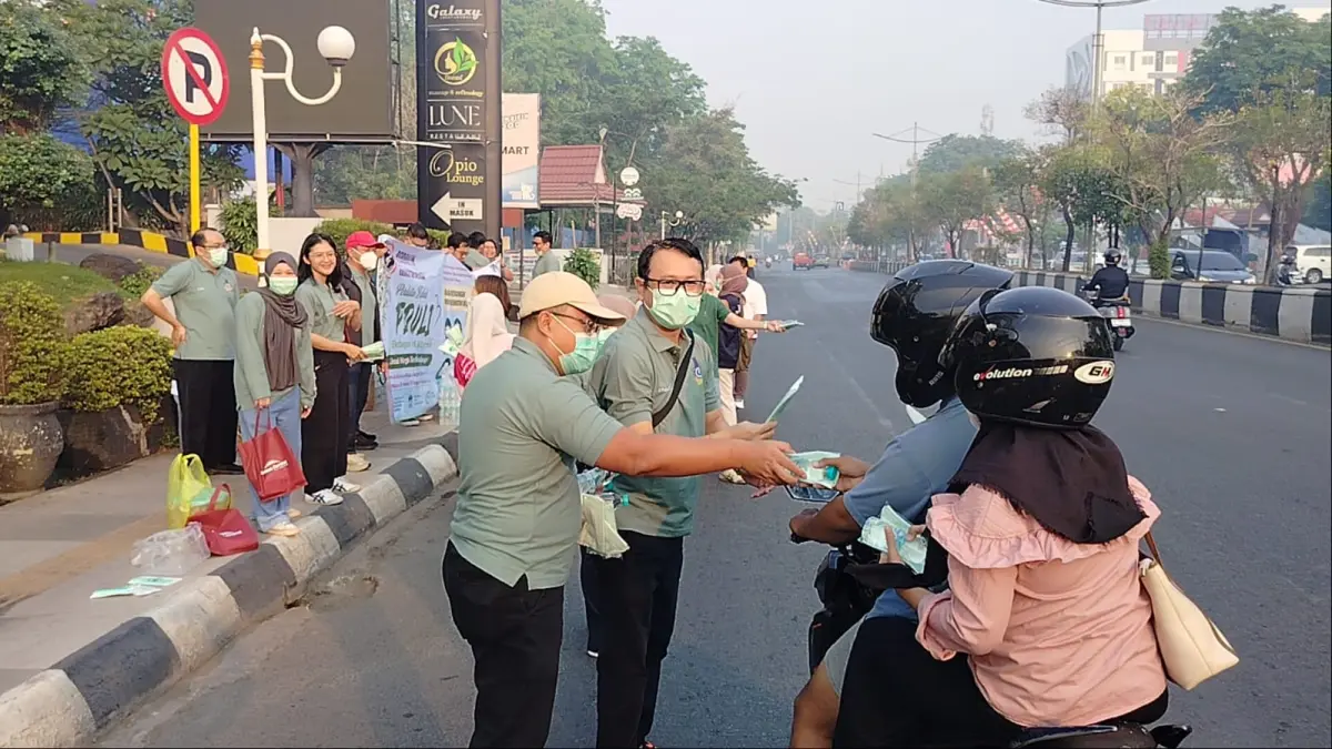 KABUT ASAP: Pengurus Perdatin Kalsel turun ke jalan membagikan masker kepada pengguna jalan di Banjarmasin.//Maulana