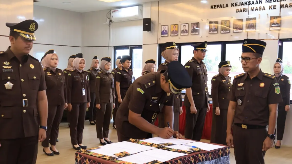 BERGESER : Denie Widya Raharja Kasi Datun Kejari Tala yang baru saat menandatangani berita acara serah terima jabatan dengan Rendy Aditya Putra Wardhana. (Foto : Kejari Tala untuk Radar Banjarmasin)