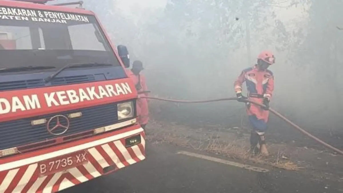 BERJIBAKU:. Petugas gabungan memadamkan api yang membakar lahan di Kecamatan Gambut. 