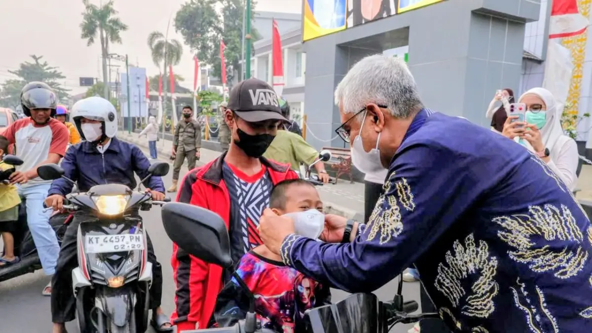 MOMEN: Wakil Bupati HSU, Hero Setiawan atau Iwan Alabio membagikan masker kepada masyarakat di Bundaran Salawat, Amuntai, di tengah kabut asap akibat karhutla, Kamis (3/9/2026).(Foto: Pemkab HSU)
