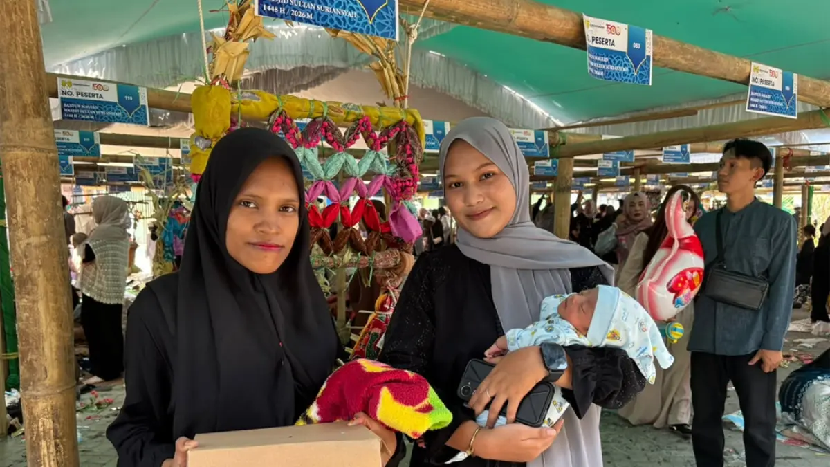 GENDONG BAYI: Fatimah (kiri) ibunda dari Aluna Callista Maharani peserta termuda dari Baayun Maulid bersama di halaman Masjid Sultan Suriansyah, Banjarmasin. Ia digendong oleh Ahda (16) yang merupakan bibi atau saudari dari Fatimah, Minggu (6/9/2026).