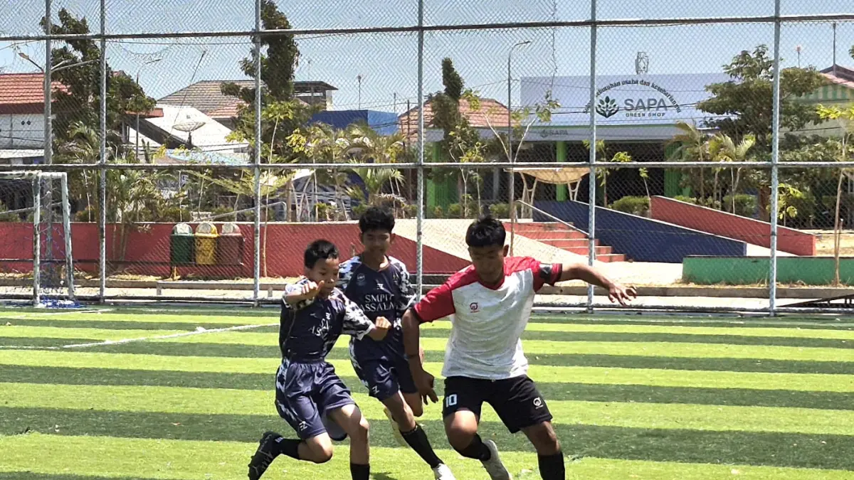 BERSAING: Pemain SMP IT Assalam (baju hitam) berebut bola dengan pemain MTsN 3 Batu Ampar. (Foto : Norsalim Yahya/Radar Banjarmasin)