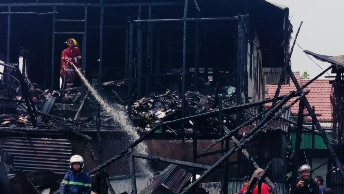 PADAMKAN: Warga dan relawan damkar berjibaku memadamkan api yang membakar rumah di Jalan Cempaka XI, Sabtu (19/9). (Foto: Maulana)