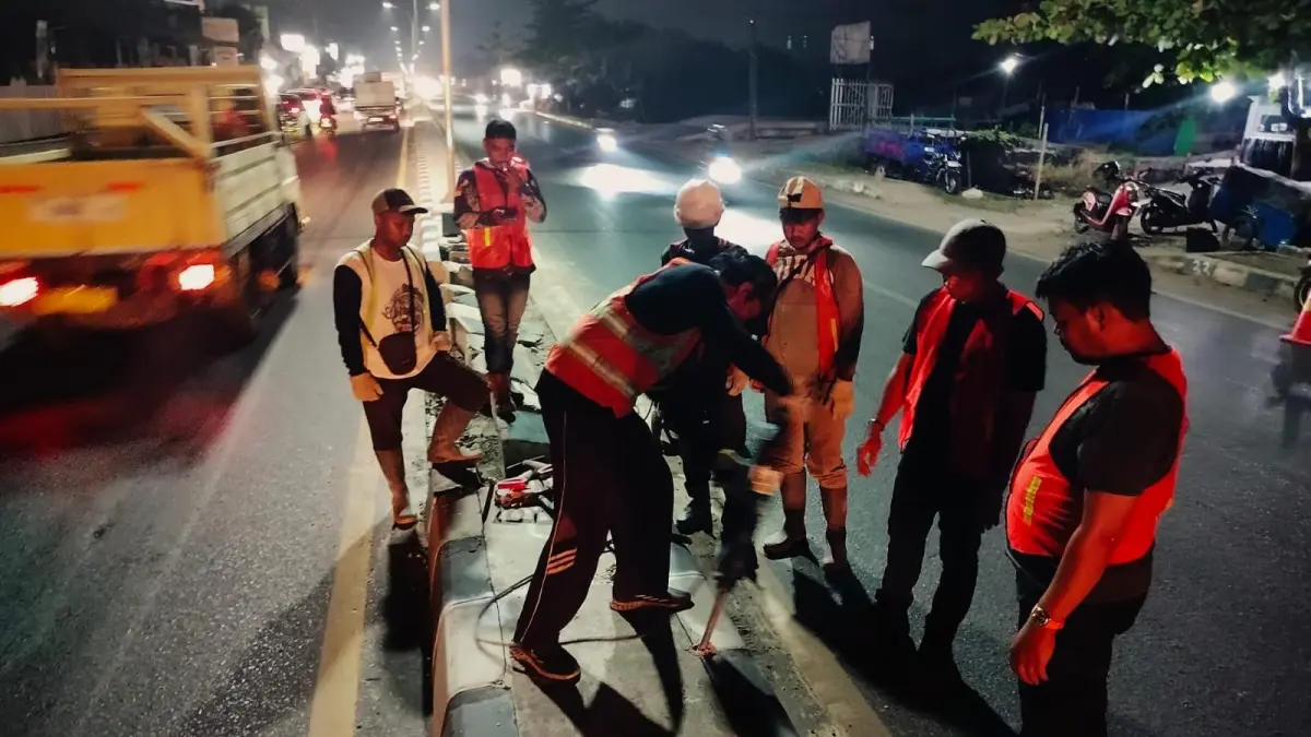 MEMBONGKAR: Pekerja membongkar median jalan untuk membuka akses putar balik di kawasan Handil Bakti. (Foto: Maulana)