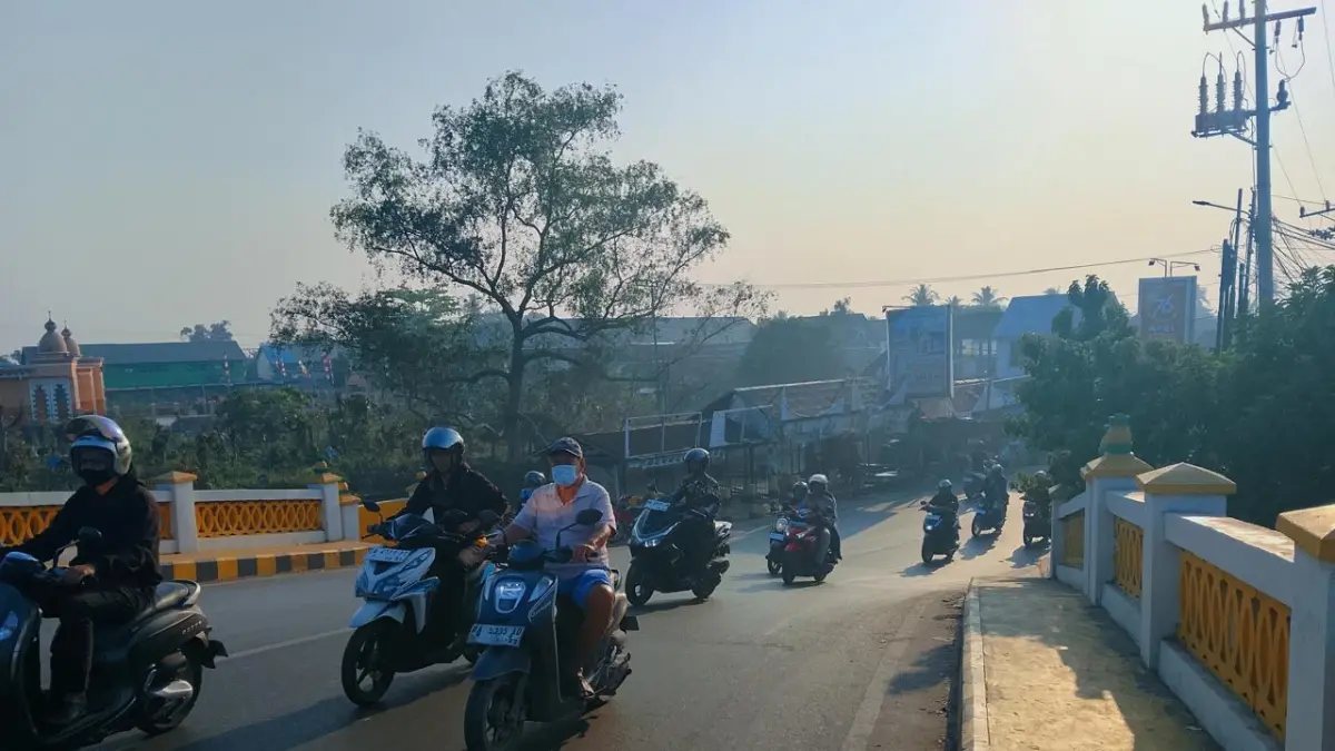 MELINTASI JEMBATAN: Warga Kota Banjarmasin beraktivitas menggunakan masker di tengah paparan kabut asap Karhutla. Dinkes Kota Banjarmasin mencatat kasus ISPA dalam empat pekan terakhir meningkat hingga 37,7 persen.(Foto: Endang Syarifuddin/Radar Banjarmasin)