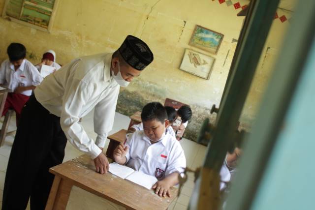 PENGABDIAN: Seorang guru agama mengajar di sekolah dasar di Kalsel (DOK/RADAR BANJARMASIN)