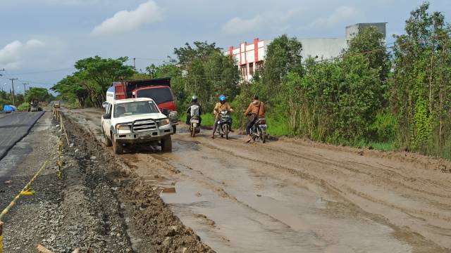 PROYEK JALAN: Pengendara mencoba melintas di proyek rehabilitasi jalan Liang Anggang-Bati-Bati, pekan tadi. Tahun ini banyak pembangunan infrastruktur di Kalsel bisa dilanjutkan setelah sempat tertunda karena refocusing beberapa waktu lalu.  | FOTO: SUTRI