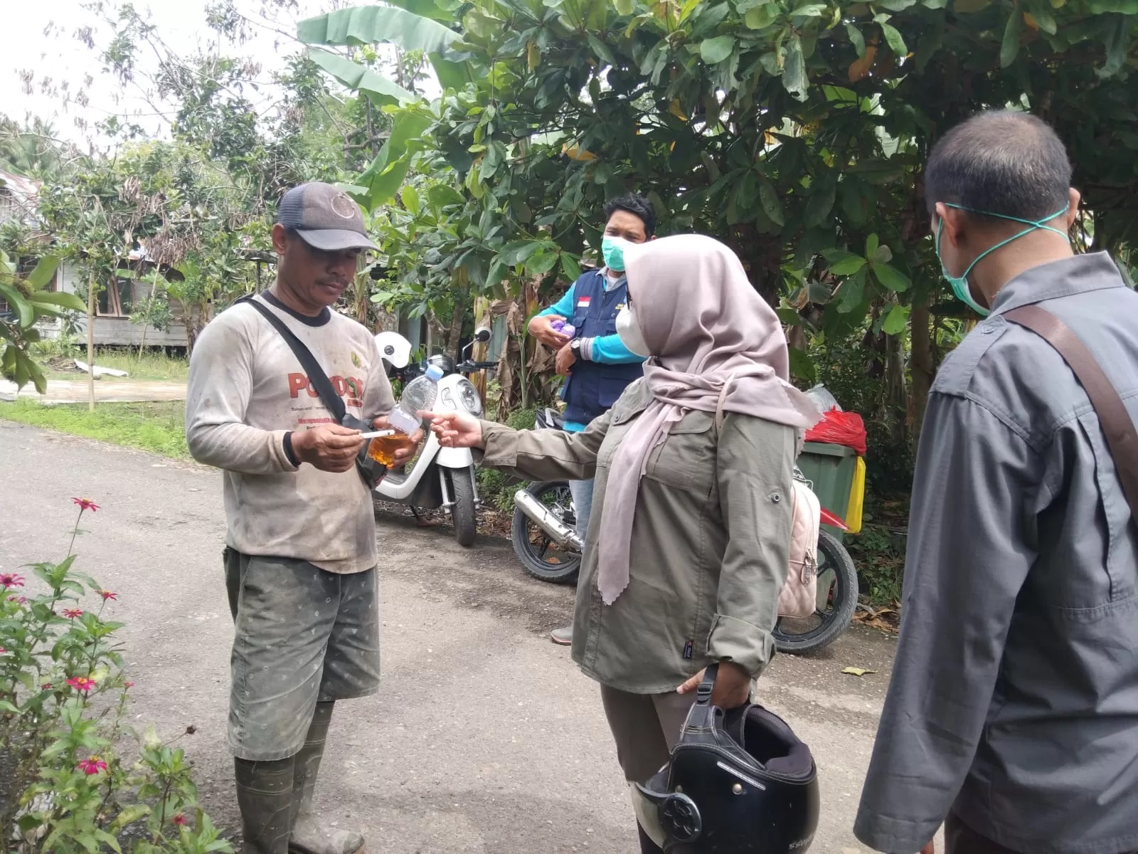 ANTISIPASI: Petugas Dinas Pertanian Kabupaten HSS membagikan obat semprot kandang kepada peternak.
