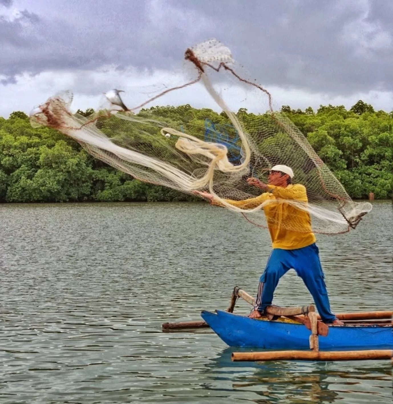 Nelayan Rawa sedang menangkap ikan dengan cara menjala.