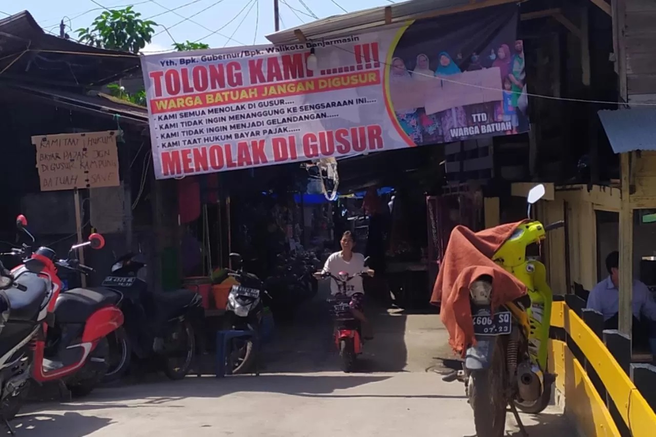NYATAKAN SIKAP: Warga memasang spanduk menolak penggusuran di depan Pasar Batuah, beberapa waktu lalu.(Foto: Wahyu Ramadhan/Radar Banjarmasin)