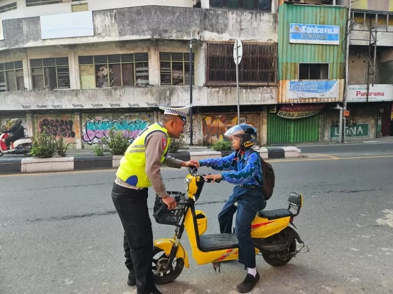 DITEGUR: Polantas menegur pelajar yang mengendarai sepeda listrik di Jalan Hasanuddin HM. (FOTO: AIPTU BUDIONO UNTUK RADAR BANJARMASIN)