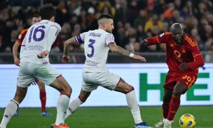 Striker AS Roma Romelu Lukaku (kanan) mencoba melewati bek Fiorentina (tengah) Cristiano Biraghi di Stadion Olimpico, Roma, Minggu (10/12/2023). (ANTARA/Alberto PIZZOLI/AFP)