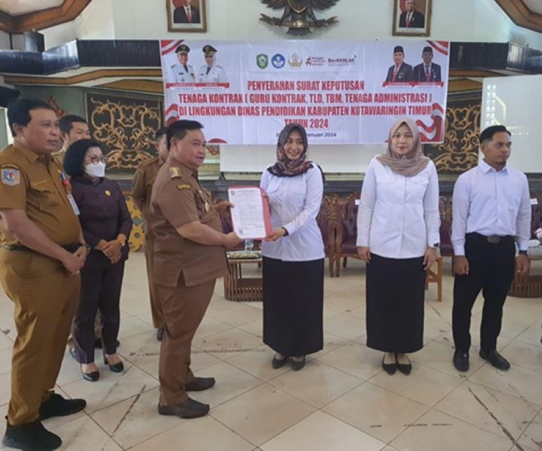 PERPANJANGAN TEKON:  Bupati Kotim Halikinnor menyerahkan SK perjanjian kontrak kerja tenaga guru di Gedung Serba Guna, Senin (29/1/2024). (HENY/RADAR SAMPIT)