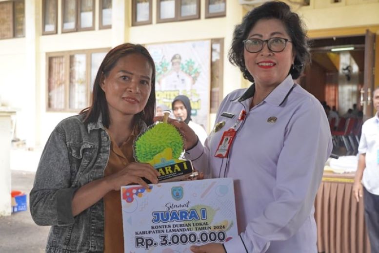 PJ Bupati Lamandau, Lilis Suriani (kiri) menyerahkan hadiah kepada juara 1 kontes durian lokal Kabupaten Lamandau, Rabu (31/1/2014) kemarin. (FOTO: BIB/PROKALTENG.CO)