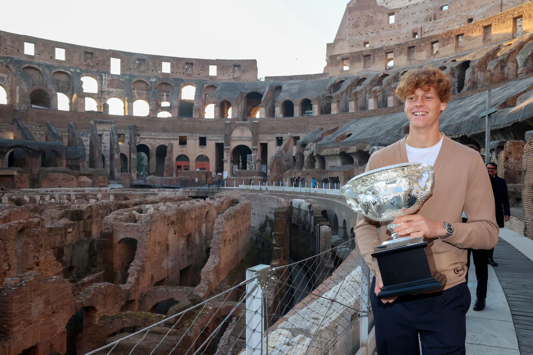 RAYAKAN DI KAMPUNG: Jannik Sinner berpose dengan trofi grand slam Australia Terbuka di Colloseum, Roma, Italia.