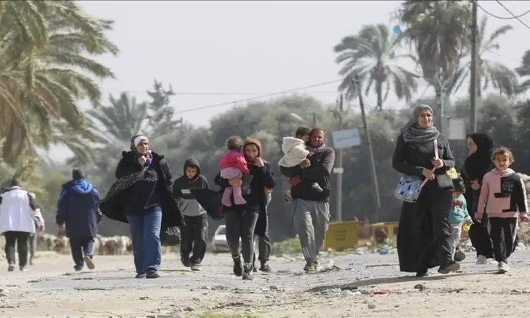 Beberapa orang dewasa dan anak-anak Palestina sedang berjalan mencari perlindungan.