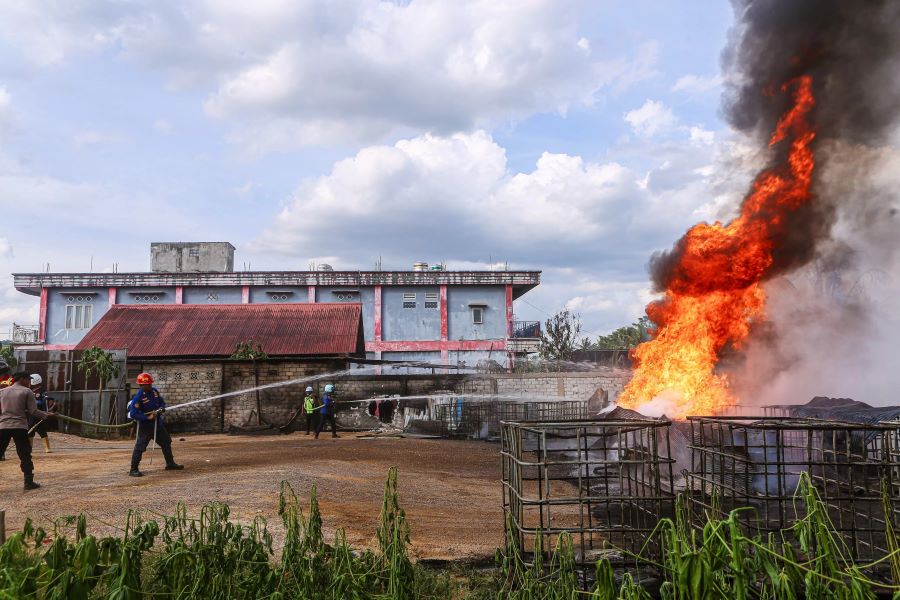 DI PERMUKIMAN: Tim dari Disdamkar Samarinda berupaya menjinakkan si jago merah yang mengamuk, dan diduga jadi tempat penyimpanan BBM.