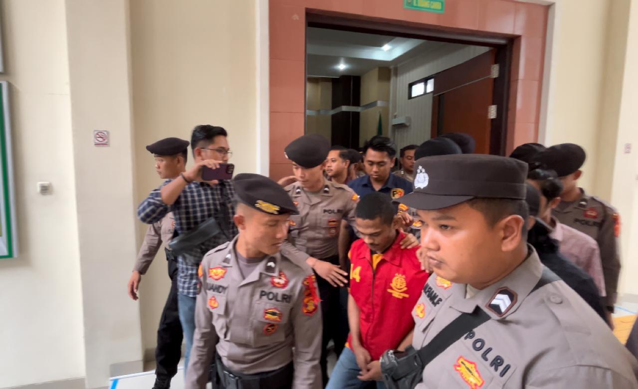 DIGIRING: Terdakwa Y dijaga aparat kepolisian seusai mengikuti sidang ketiga di Pengadilan Negeri Tanjung Redeb.