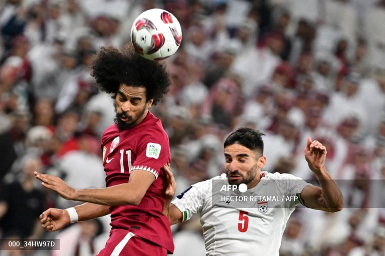 Pemain Qatar, Akram duel udara dengan pemain Iran.