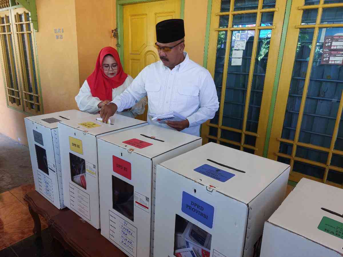 Bupati Kukar Edi Damansyah dan sang istri, Maslianawati saat melakukan pencoblosan di TPS 041 Timbau, Tenggarong.