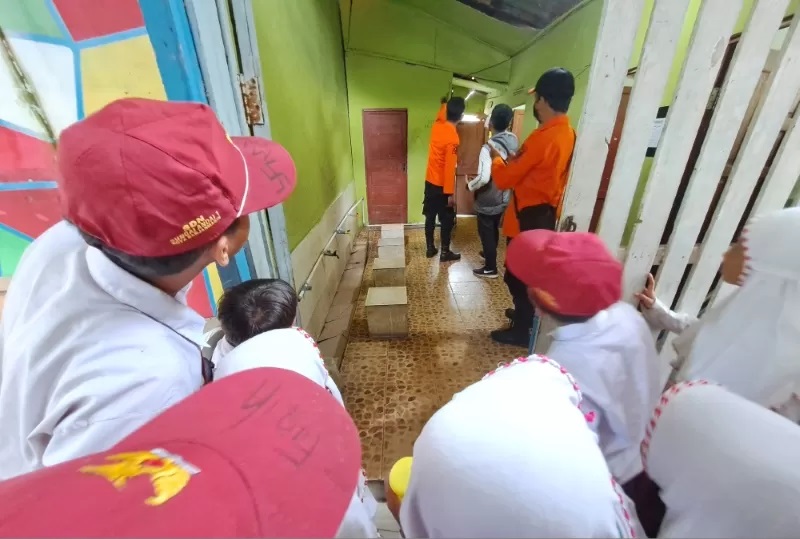DITONTON SISWA: Petugas BPBD Banjarmasin ketika mengecek bangunan SDN Sungai Jingah 5 yang diduga retak akibat gempa kemarin (13/2). (FOTO: WAHYU RAMADHAN/RADAR BANJARMASIN)