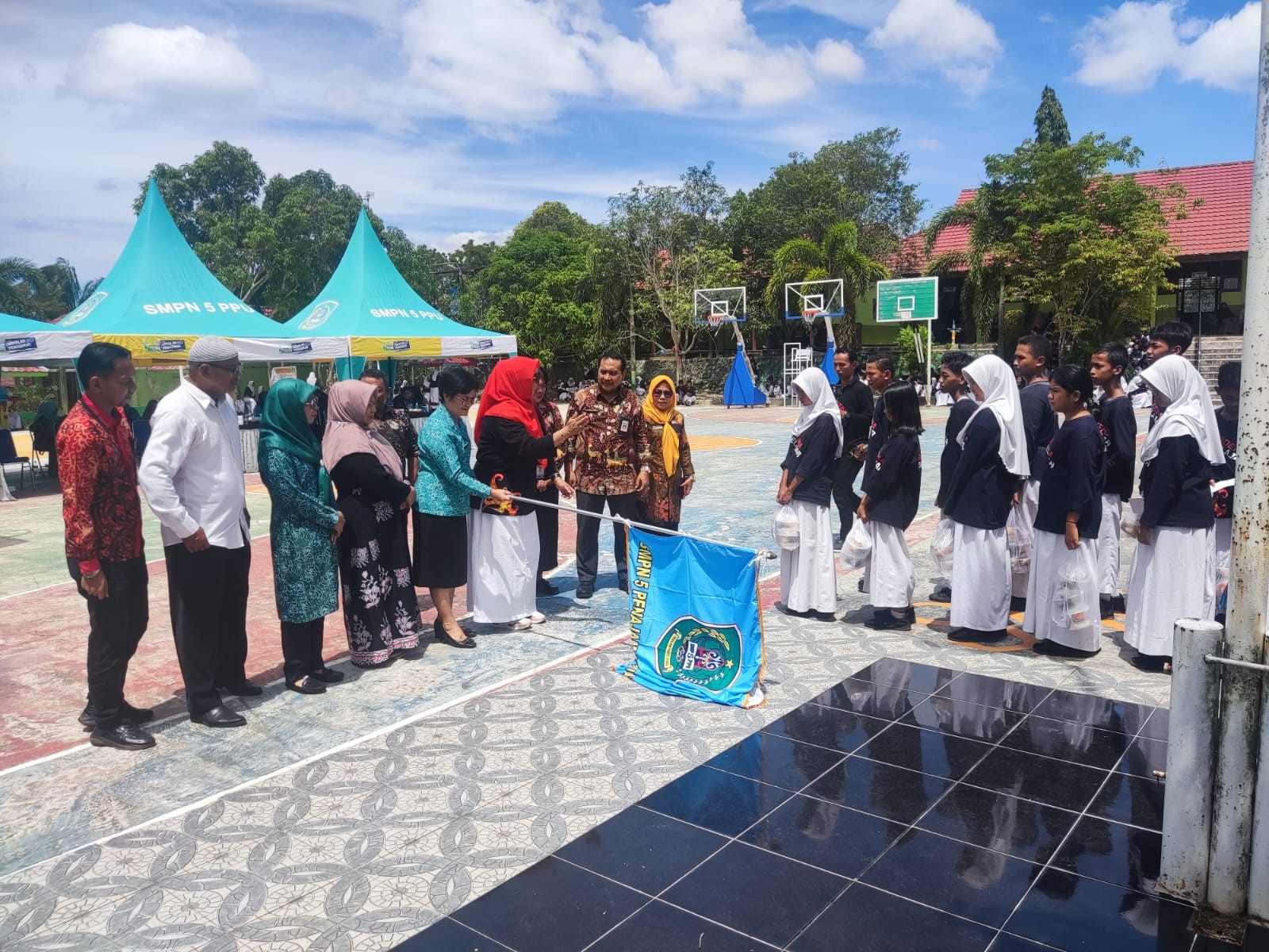 PERDANA : Linda Romauli Siregar mengibarkan bendera start untuk siswa &ndash; siswi SMP 5 Penajam dalam membagikan makanan bergizi dalam pembukaan perdana SLP, Kamis (15/2) kemarin.