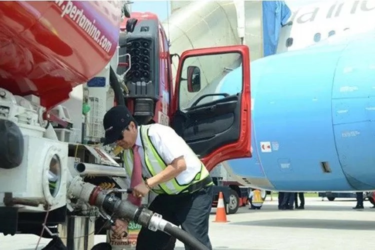 Petugas sedang mengisi avtur ke pesawat terbang.